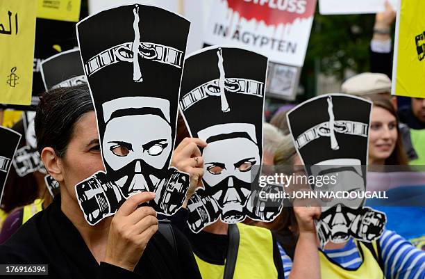 Selim Caliskan , Germany head of human rights organisation Amnesty International, and other activists hold up masks featuring Egyptian Pharaoh...