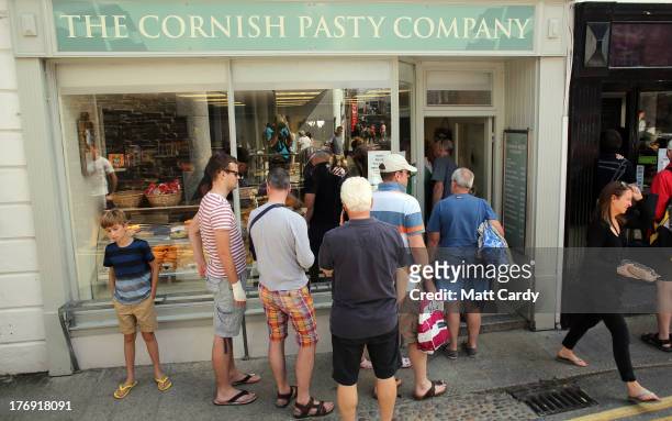People queue outside a pasty shop in a street near the harbour on August 19, 2013 in Padstow, England. Over recent years, the traditional Cornish...
