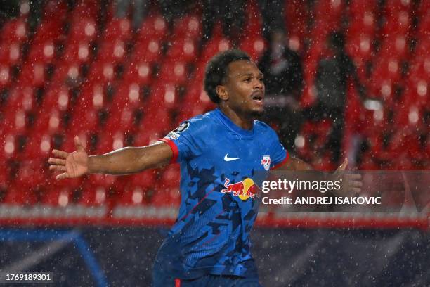 Leipzig's Belgian forward Lois Openda celebrates in the rain after scoring Leipzig's second goal during the UEFA Champions League Group G football...