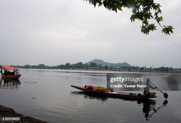 Kashmiri Muslim boatman rows a boat filled with flowers on Da lake August 19, 2013 in Srinagar, the summer capital of Indian administered Kashmir,...