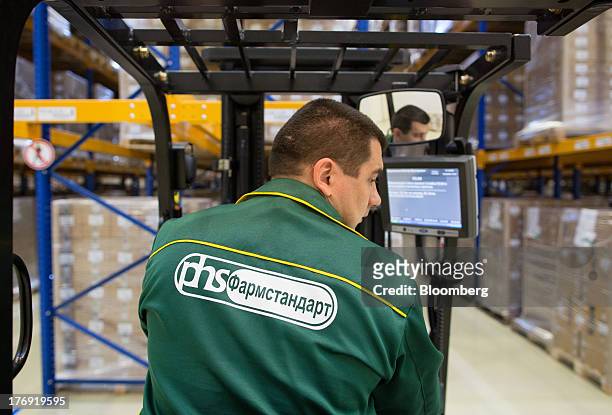 An employee drives a forklift truck around the storage facility at OAO Pharmstandard's Leksredstva drug manufacturing unit in Kursk, Russia, on...
