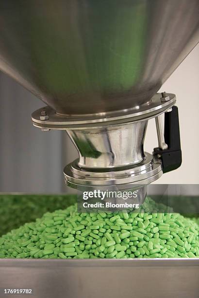 Pentalgin tablets fall from a machine into a collection tray during production at OAO Pharmstandard's Leksredstva drug manufacturing unit in Kursk,...