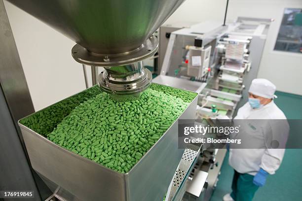 Pentalgin tablets fall from a machine during production at OAO Pharmstandard's Leksredstva drug manufacturing unit in Kursk, Russia, on Friday, Aug....