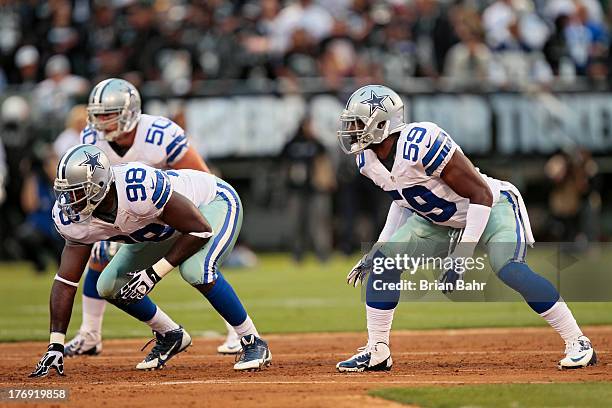 Defensive end George Selvie and linebacker Ernie Sims of the Dallas Cowboys wait for a snap against the Oakland Raiders in the first quarter of a...
