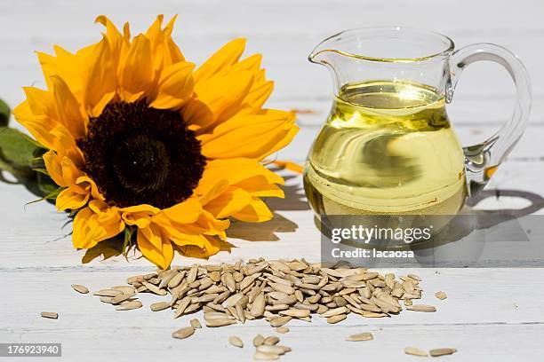 sunflower seeds, sunflower oil and blossom - zonnebloempit stockfoto's en -beelden