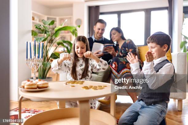 jewish family celebrating hanukkah - hanukkah stock pictures, royalty-free photos & images