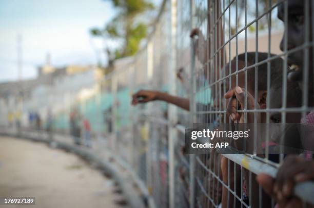 Youths look at children playing football near a camp for Internally Displaced Persons in Mogadishu, Somalia, on August 19 during the FIFA Football...