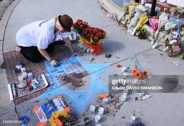 Chalk artist Elana Colombo on November 7, 2023 draws the Star of David around the blood of Paul Kessler, a Jewish man who died following an...