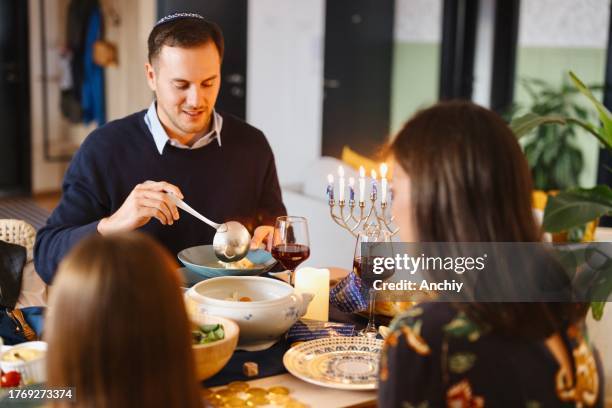 man eating a traditional matzo ball soup at the dining table - jewish people stock pictures, royalty-free photos & images
