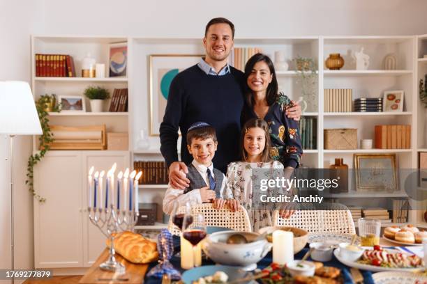 portrait picture of jewish family during traditional hanukkah dinner - sufganiyah stock pictures, royalty-free photos & images