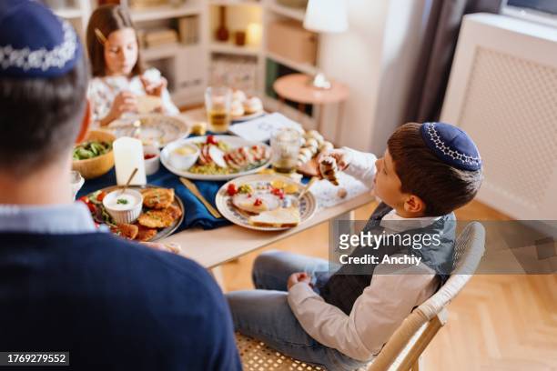 little boy eating rugelach - jewish religion stock pictures, royalty-free photos & images