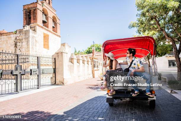 tourist couple in rickshaw ride in historic district - santo domingo dominican republic stock pictures, royalty-free photos & images