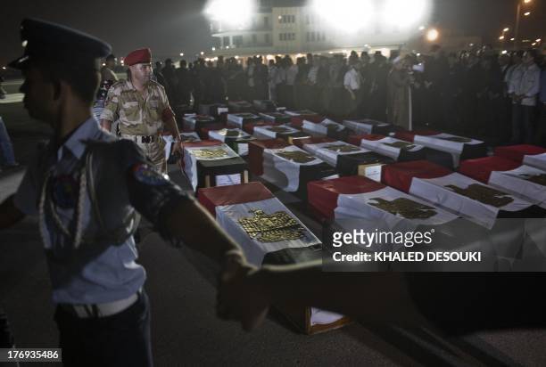 Egyptian army surround the coffins covered with the national flags at Almaza military Airbase in Cairo on on August 19 during a funeral for 25...