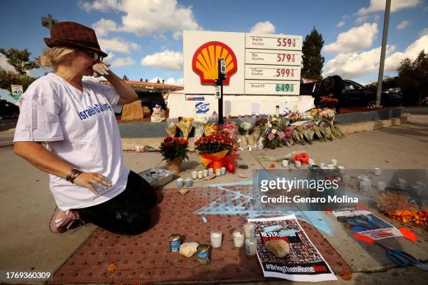 Elena Columbo, from Hamakom Synagogue, pauses from creating a Star of David in chalk at a growing memorial fro Paul Kessler at the corner of S....