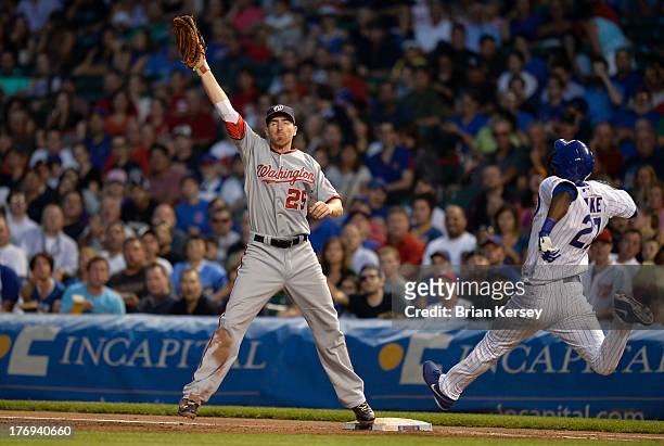First baseman Adam LaRoche of the Washington Nationals catches the throw from third baseman Ryan Zimmerman to retire Junior Lake of the Chicago Cubs...