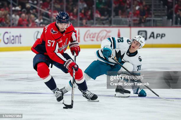 Trevor van Riemsdyk of the Washington Capitals skates with the puck in front of William Eklund of the San Jose Sharks during the first period of the...