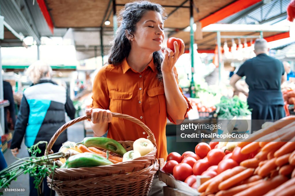 Woman picks vegetables with care in market