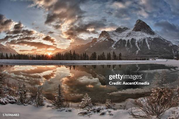 Sun rises above mountain lake, after snowfall