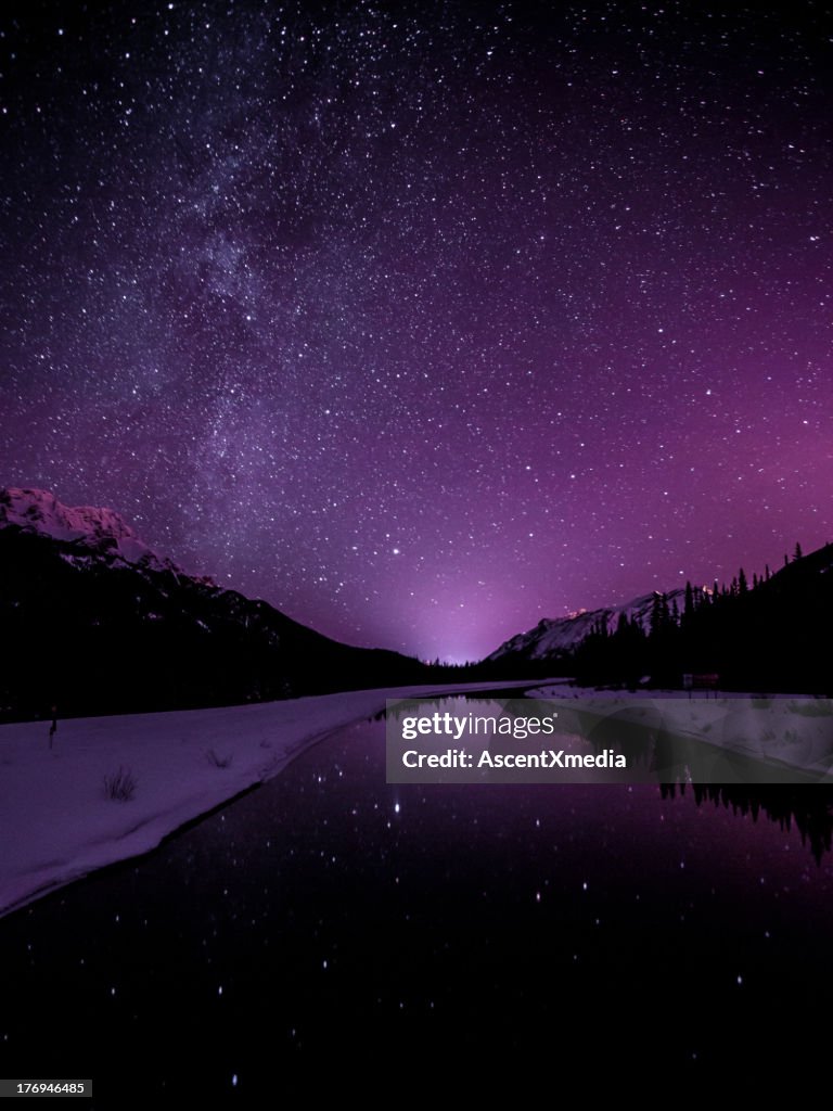 Starry sky illuminates mountain landscape