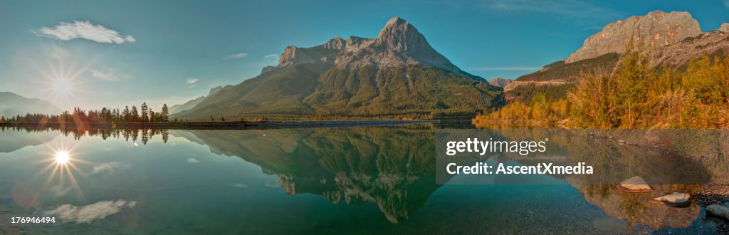 Sun rises above mountain lake, autumn