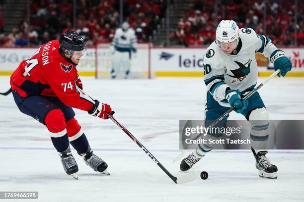 John Carlson of the Washington Capitals and Fabian Zetterlund of the San Jose Sharks vie for the puck during the third period of the game at Capital...