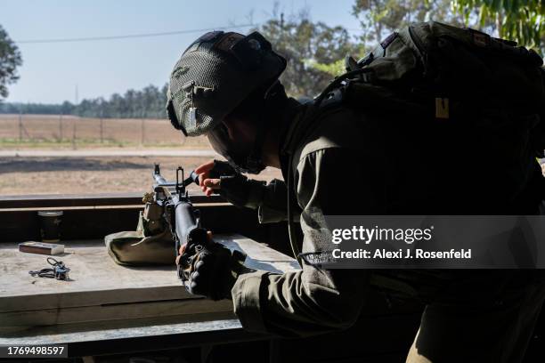 An IDF soldier sets up a light machine gun near where Hamas broke through the fence and attacked this kibbutz on Oct 7th near the border of Gaza on...