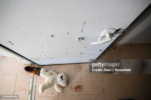 Teddy bear is left on the ground near pools of blood staining the floor where two grandparents held the bomb shelter door closed to protect their...