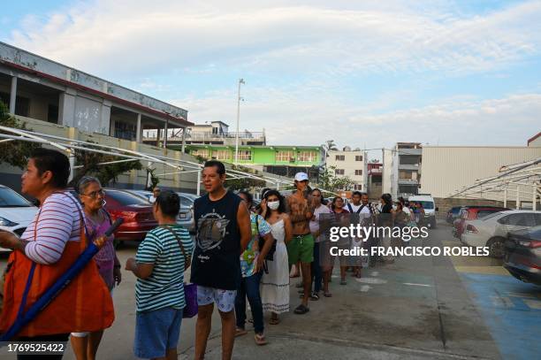 Residents of Acapulco wearing face masks due to the increase of bad smell caused by piled garbage and debris after the passage of Hurricane Otis,...