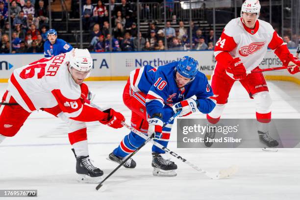 Artemi Panarin of the New York Rangers skates with the puck against Christian Fischer of the Detroit Red Wings at Madison Square Garden on November...