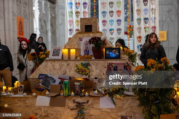 People visit a chapel with candles and remembrances of the deceased on the grounds of Greenwood Cemetery during a celebration of Día de los Muertos...