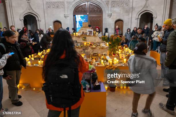People visit a chapel with candles and remembrances of the deceased on the grounds of Greenwood Cemetery during a celebration of Día de los Muertos...