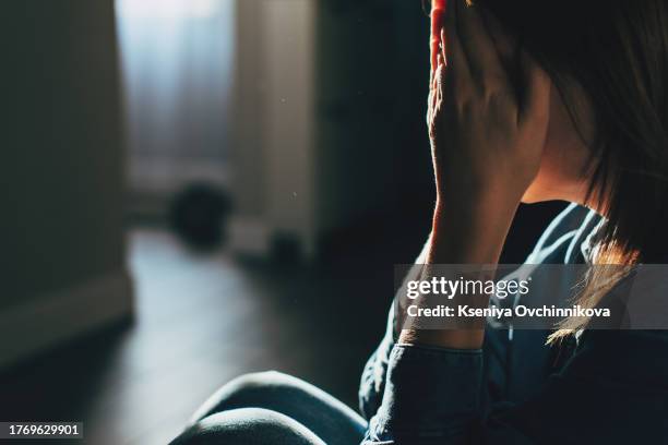 silhouette of sad and depressed woman sitting on the floor at home - blame stock pictures, royalty-free photos & images