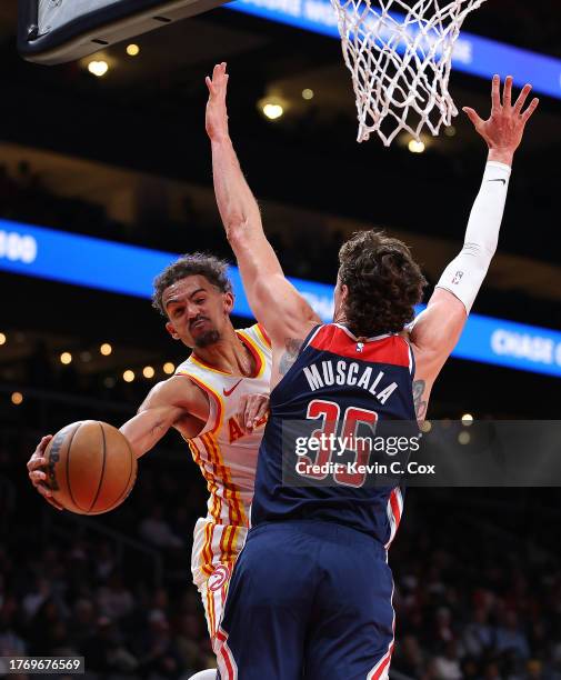 Trae Young of the Atlanta Hawks passes the ball as he drives against Mike Muscala of the Washington Wizards during the second quarter at State Farm...