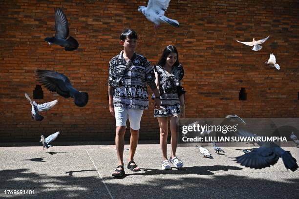 This photo taken on October 18, 2023 shows a Thai couple wearing elephant print clothing near Thapae Gate in the northern Thai province of Chiang...