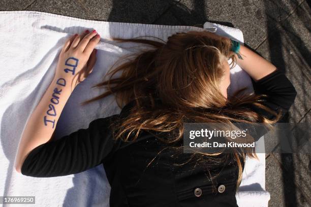 One Direction fans take their positions in Leicester Square ahead of the premier to the bands new film on August 20, 2013 in London, England. The...