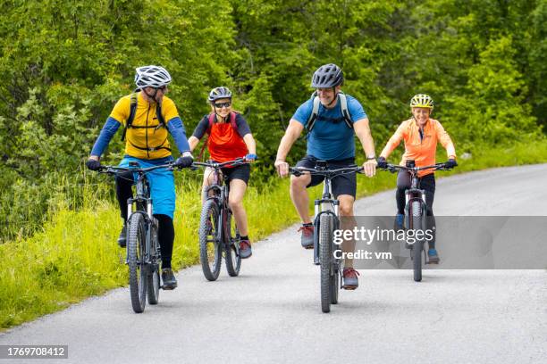 people riding electric mountain bikes - mid adult stock pictures, royalty-free photos & images