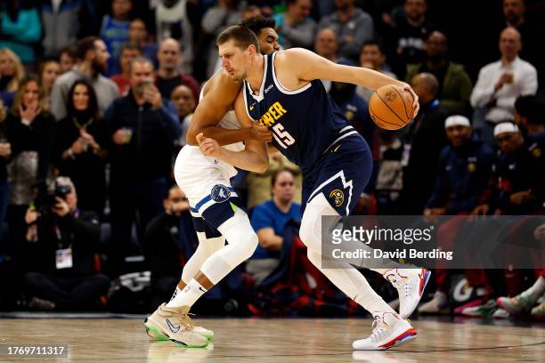 Nikola Jokic of the Denver Nuggets drives to the basket while Karl-Anthony Towns of the Minnesota Timberwolves defends in the first quarter at Target...