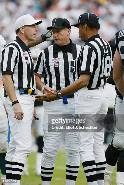 Referee Terry McAulay, umpire Ed Coukart and line judge Byron Boston huddle to discuss the play during the NFL game between the Oakland Raiders and...