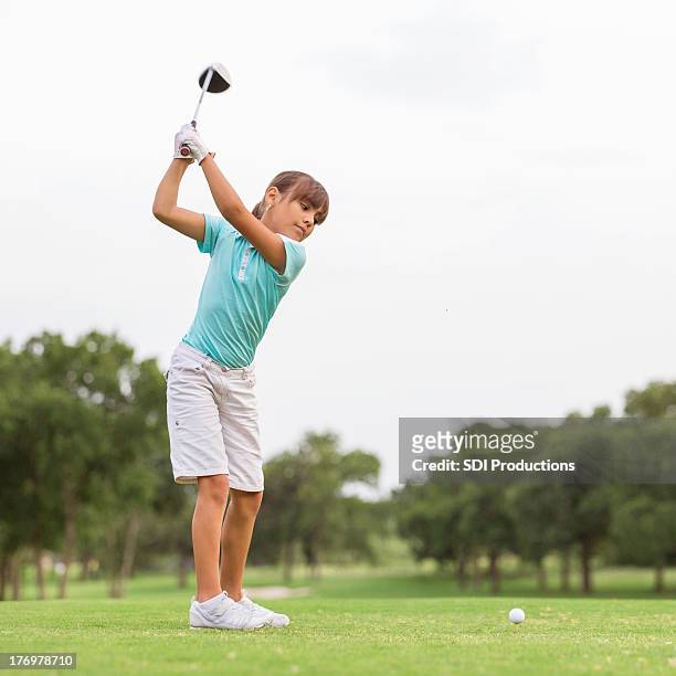 young golfer teeing off on beautiful golf course - play off stock pictures, royalty-free photos & images