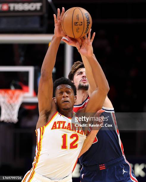 De'Andre Hunter of the Atlanta Hawks draws a foul from Deni Avdija of the Washington Wizards during the fourth quarter at State Farm Arena on...