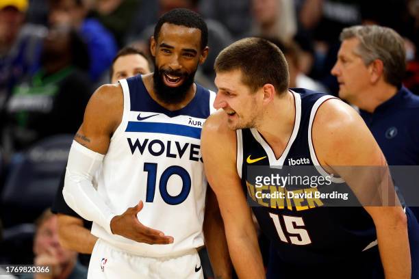 Mike Conley of the Minnesota Timberwolves and Nikola Jokic of the Denver Nuggets interact in the third quarter at Target Center on November 01, 2023...