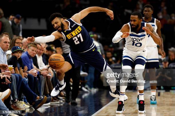 Jamal Murray of the Denver Nuggets reaches for the ball against Mike Conley of the Minnesota Timberwolves in the third quarter at Target Center on...