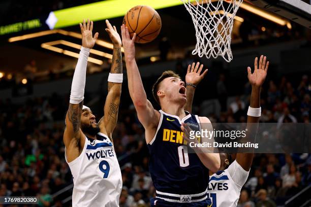 Christian Braun of the Denver Nuggets goes up for a shot past Nickeil Alexander-Walker of the Minnesota Timberwolves in the third quarter at Target...