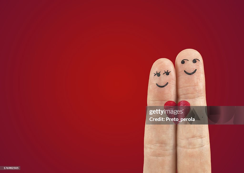 Happy couple in love with painted smiley and hugging