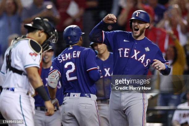 Marcus Semien and Jonah Heim of the Texas Rangers celebrate after Semien hit a home run in the ninth inning against the Arizona Diamondbacks during...