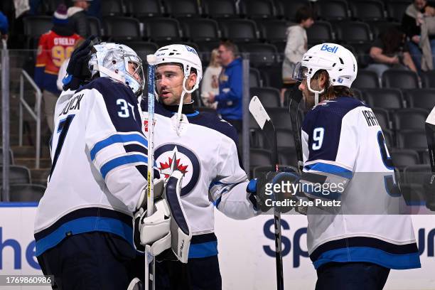 Connor Hellebuyck Neal Pionk and Alex Iafallo of the Winnipeg Jets celebrate their team's 5-2 victory over the St. Louis Blues on November 7, 2023 at...