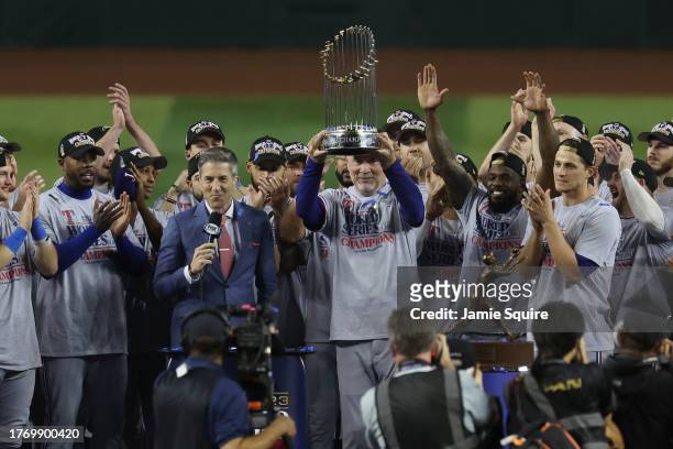 Manager Bruce Bochy of the Texas Rangers hoists the Commissioner's Trophy after the Texas Rangers beat the Arizona Diamondbacks 5-0 in Game Five to...