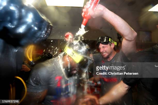 Adolis García and Max Scherzer of the Texas Rangers celebrate in the clubhouse after the Texas Rangers beat the Arizona Diamondbacks 5-0 in Game Five...