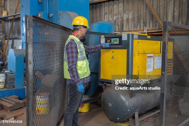 industriearbeiter, der luftkompressor in einer fabrik programmiert - kompressor stock-fotos und bilder
