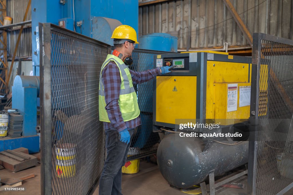 Trabalhador industrial programando compressor de ar em uma fábrica